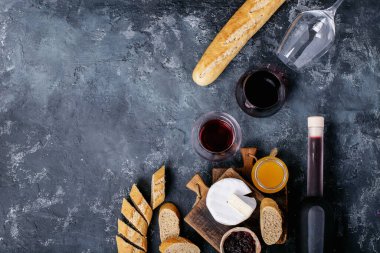 Bir bardak kırmızı şarap, peynirli camembert peyniri, bal, reçel ve Fransız ekmeği ile servis edilir. Üst manzara, düz yatış. Boşluğu kopyala