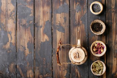 Seramik fincanlarda siyah ve yeşil çay seramik çaydanlık ve kahverengi ahşap zemin üzerinde gül yaprakları. Üst Manzara. Boşluğu Kopyala