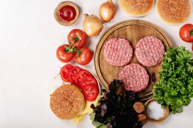 Çiğ ev yapımı taze sebzeli hamburger: marul, soğan, domates ve ketçap. Üst manzara, düz yatış. Boşluğu kopyala