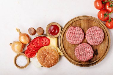Çiğ ev yapımı taze sebzeli hamburger: marul, soğan, domates ve ketçap. Üst manzara, düz yatış. Boşluğu kopyala