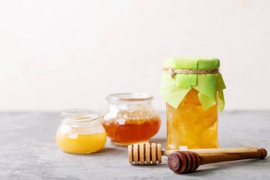 Beyaz desenli arka planda bal ile servis edilen bir bardak siyah çay.