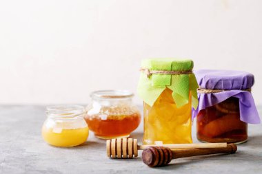 Beyaz desenli arka planda bal ile servis edilen bir bardak siyah çay.