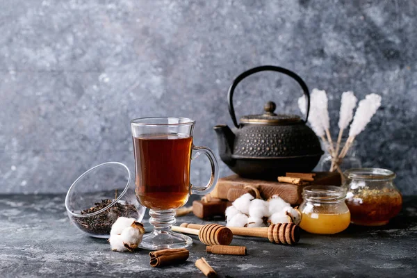 茶壶一种黑色金属茶壶和一杯玻璃杯中的茶 用蜂蜜和山羊花在深色质感的背景下饮用 — 图库照片