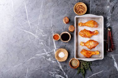 Taze kekik, tuz, biber taneleri, kekik ve barbekü soslu çiğ tavuk budu. Üst manzara, düz yatış. Boşluğu kopyala