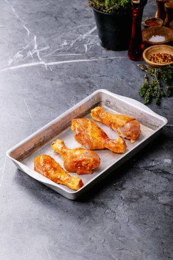 Taze kekik, tuz, biber taneleri, kekik ve barbekü soslu çiğ tavuk budu.