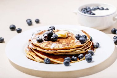 Beyaz arka planda bal ve yaban mersinli krep yığını..