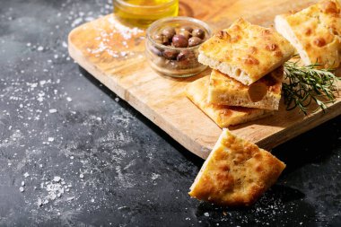 Zeytinli fırınlanmış Focaccia ekmeği. Koyu dokuda biberiye ile geleneksel İtalyan Focaccia