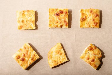 Pişmiş Focaccia ekmeği. Beyaz doku üzerine biberiyeli geleneksel İtalyan Focaccia 'sı. Üst manzara, düz yatış. Boşluğu kopyala