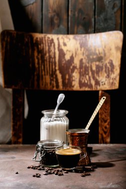 Kahverengi ahşap arka planda şekerli ve kahve çekirdekli cam bardakta taze kahve. Üst manzara, düz uzanma