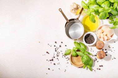 Beyaz seramik zemin üzerinde taze fesleğen ve parmesan peyniri ile zeytin yağı. Boşluğu kopyala