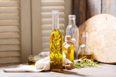 Cam şişelerde biberiyeli zeytinyağı koyu ahşap arka planda. Üst manzara, düz yatış. Boşluğu kopyala