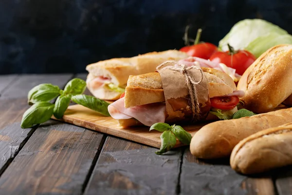 自制三明治 西红柿 生菜和法式面包 放在木制切菜板上 背景为褐色 — 图库照片