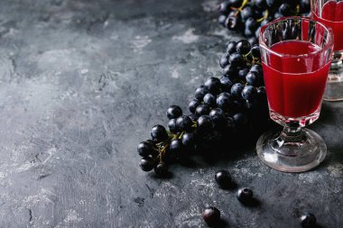 Geleneksel düşük alkollü kırmızı ve beyaz şarap Federweisser, siyah ve yeşil üzümlerle servis edilen gözlüklerle Burcak koyu dokulu arka plan