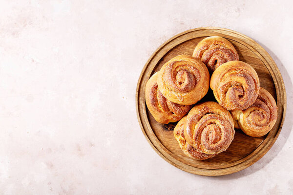 Baked cinnamon buns served with cinnamon and coffee over white texture background. Top view, flat lay. Copy space