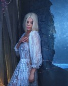 sexy, gotisch, Schneekönigin im weißen Vintage-Kleid. Ein blondes Mädchen mit sehr langen Haaren posiert an einer Wand in der Nähe eines Fensters. Gothic Photography in kalten Farben. die Legende vom Banshee. künstlerisches Foto.