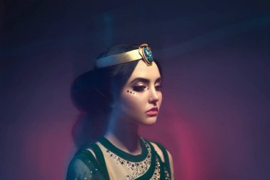 Bir kız oryantal kıyafetleri, fırtına kraliçesi bir kız. Prenses Yasemin. Arka plan bir bükülme ve güçlü bir rüzgar var. Karışık ışığıyla çekim stüdyosu. Sanatsal fotoğraf