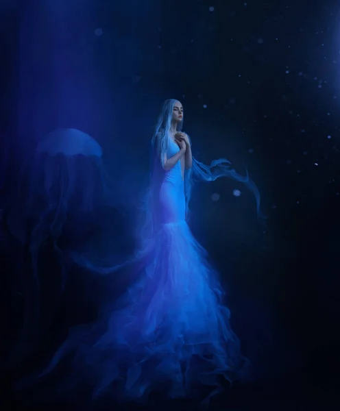 一个水母女孩漂浮在一个黑暗的海底悬浮 一条美丽的白色连衣裙和一顶带有触角的帽子 上面飘着水 外星人创造 艺术照片 — 图库照片