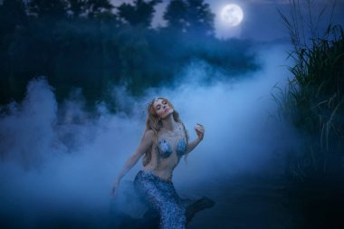 Neptunes kızı emer ve mehtap yiyor, muhteşem deniz cetvel gece nehre bir taş oturur ve kalın bir sis, fotoğraf işleme sanatı ile muhteşem bir karakter aittir