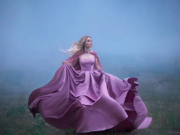 Excellent mysterious blonde lady runs away from a nightmare, a forest monster, her light long expensive royal dress flutters on the fly, takes the form of a magical flower an amazing photo in motion — Stock Photo, Image