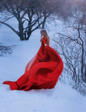 sarışın kadın fotoğrafta güzel şaşırtıcı kırmızı harika elbise uzun tren ve çıplak omuzları ile giyinmiş yüzü göstermez, onun hem f elbisesi flep, kumaş büyülü dalgası yaratıyor