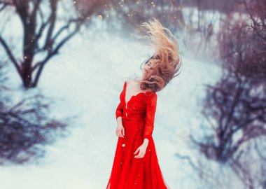 Sarışın kız saçını bir kış manzarası zemin karşı sallayarak. Derin bir yaka ile kırmızı bir elbise prenses. büyü ve payetler ile sanatsal işleme.