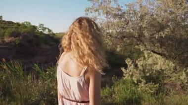 kız dansçı dönüyor, onu bukleler yüzünde düşmek. yeşil tepelerin arka plan