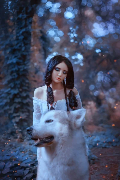 Волшебная фея седлает гордых волков леса и едет с ними, хищник берет принцессу эльфов в свое логово, встречает нового друга, темноволосую привлекательную куклу в белом светлом платье с Аляской Маламут — стоковое фото