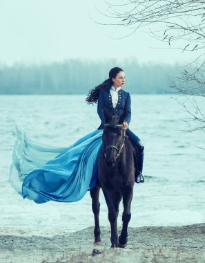 gorgeous countess in a strict blue suit and high leather boots, sexy hot cheeky girl with Amazon skirt with long flying train, princess on a black horse, confident brunette with long curled hair clipart