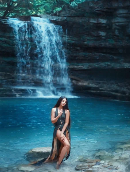Georgia natureza mágica em Martvili Canyon, menina sexy de cabelos escuros sai do azul transparente água do lago cachoeira clara, ninfa do mar em lindo vestido verde com decote profundo e cortes no trem — Fotografia de Stock
