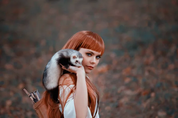 Attractive lady playfully and temptingly looks into camera, girl with fiery red hair and bangs holds cute tamed ferret on hand, charming passionate hunter with quiver of arrows behind her back — 图库照片