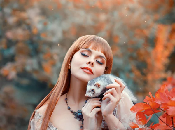 çekici kızı ateşli kırmızı düz saç onun evde beslenen hayvan ile oynar, elf prensesi vahşi gelincik ile hayvan peri çalış, omzunda eline almıştır. güneşin bir Bayan Sonbahar Makyaj.