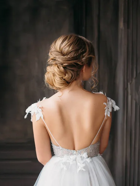 Penteado profissional lindo para cabelos longos loiros, anúncio publicitário do salão de beleza para o casamento e o baile de formatura 2019, imagem do graduado em vestido adorável caro branco com costas abertas — Fotografia de Stock