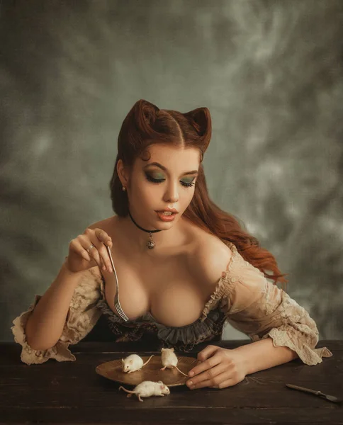 charming redhead lady with cat ears made of hair eats white mice from golden dishes. Countess pussycat eats cute animals. sexy lady in vintage dress, creative work of makeup artist and hairdresser