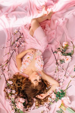 Bahar görüntüsünü, tatlı ve nazik bayan arıyorum doğrudan kamera, portre fotoğraf makyöz ve Kuaför harika iş ile bir gül çiçek gibi bir kız, uzun güzel pembe elbiseli