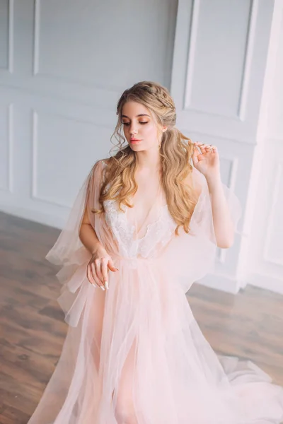 Lady in pink luxurious light dress in spacious room with white walls and bright light, gentle lace peignoir and veil, new story about sleeping beauty morning, girl with blond hair with closed eyes — Stock Photo, Image