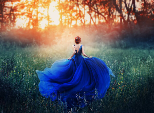Princess, with a elegant hairstyle, runs through a forest glade to meet a fiery sunset with a haze. A luxurious blue dress with a long train flutters in the wind. Photo from the back without a face.