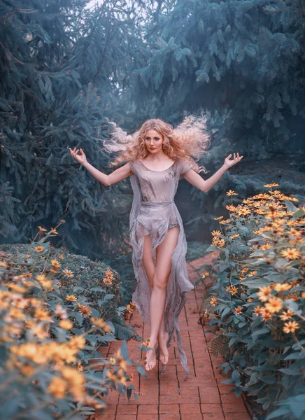 A renaissance country girl caring for a garden, the love of flowers returns her soul and she flies from happiness. The young healer, good forest witch. Photos of levitation and soaring in the air. — Stock Photo, Image