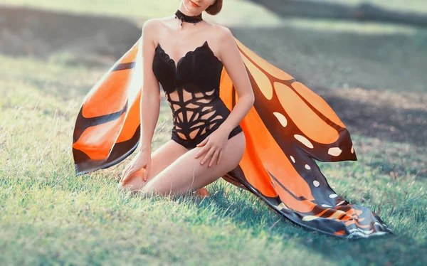 Verbazingwekkende delicate sexy Butterfly kostuum in heldere oranje tinten, creatieve zwarte strakke Romper, verleidelijke afbeelding van nachtvlinder, slank meisje met checker op nek, kostuum voor Halloween, foto zonder gezicht — Stockfoto