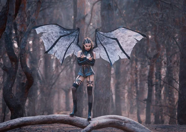 Chauve-souris fille avec un sourire cruel sanglant en costume sexy de jupe en latex noir, ceintures et bas en cuir, attaques de démons de la forêt vagabonds innocents, incarnation de succube, dame lubrique avec des ailes et des griffes — Photo