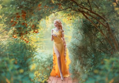 Beautiful young blond woman with very long hair that is braided. The girl is dressed in a seductive yellow dress with a slit on the leg. Fashion model posing against the backdrop of an autumn garden. clipart