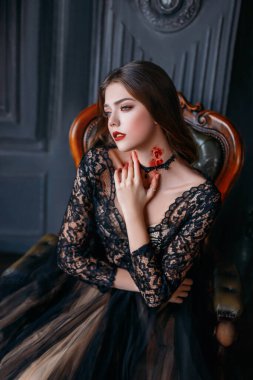 Güzel yetişkin bir kız, boynunda kanlı bir ısırık olan bir vampirin kurbanı. Siyah gotik elbiseli genç bir kadın. Cadılar Bayramı partisi için yaratıcı makyaj ve karnaval kostümü. Karanlık oda arkaplanı