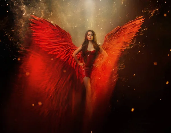 An adult beautiful fantasy girl a fallen angel with spread huge red wings. Art black background with sparks, glitters and flames. The power of a sexy demon woman. Carnival short latex seductive dress. — Stock Photo, Image