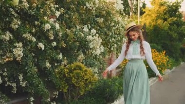 Neşeli, mutlu, genç bir kadın. Kızıl, uzun, gevşek saçlar. Sinek rüzgarı. Sihirli güneş ışığına yükselen dans eden sevimli kız gün batımını aydınlatıyor. Güzel, gülen surat. Yaz doğası ağaçları reçineler. tekne şapkası 