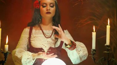 Cadılar Bayramı kadını Fantezi cadı güzel çingene kız, karanlık gotik odada kader kristali küresi öngörüyor. Mistik eski sanat klasik astrolojisi. Falcı kadın geleceği okuyor. sihirli ışık.