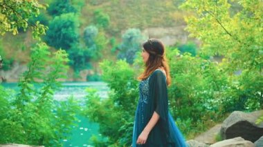 Fantazi Kraliçesi evcil ejderhaya sevgiyle dokunuyor. Sihirli yaz ağaçları yeşil yapraklar rüzgar yapar. Kafasında elf ipeği gibi uzun bir taç vardı. Prenses tanrıça seksi manken kız. Efsane hayvan. 4k 