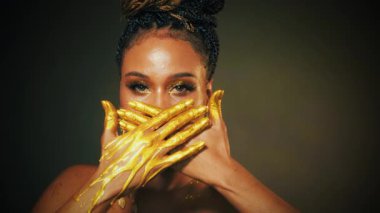 Fantezi sanat portresi mavi gözler kapanıyor, Afro-Amerikan kadının yüzüne bakıyor. Profesyonel altın makyaj, parlak gölgeler. Elleri altın likit damlalarda akıyor. Model kız. Stüdyo siyah