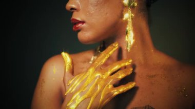 Portre Afrikalı kadın manken güzel yüzünü yakından çek. Göz kamaştırıcı lüks seksi kız mükemmel ten, akşam tatili parlak makyaj parlatıcısı dudak parlatıcı, uzun küpeler altın rengi sıvı boya, siyah stüdyo boyası