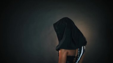 Gürültülü video. Afro-Amerikan kadın, fantezi portresi gecenin kraliçe rahibesi. Başında gümüş kapüşonlu taç var. Yaratıcı siyah tasarım. Cadı kız seksi bir şekilde kameraya bakar. Cadılar Bayramı kostümü.