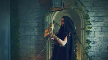 Yakın plan fantezi vampir kadın, siyah Gotik klasik elbise, kafasında başlık. Vahşi kuş beyaz ahır baykuşu evcil hayvanıyla güzel bir kız. Cadılar bayramı şenliği makyajı gotik karanlık kraliçe. taht odası