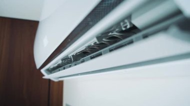 Kapalı mekandaki havalandırma odasının duvarına yakın çekim yapılmış. Soğuk, soğuk hava, serinletici ev. Modern teknolojiler. Kanatlar açılır, panjurlar açılır, soğuk hava alır. Video 4k